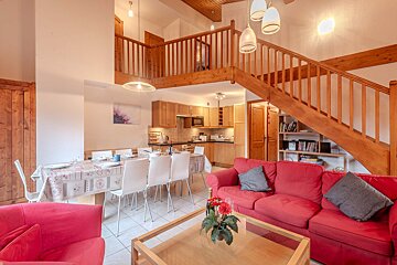 A living room with red furniture and a flat screen tv
