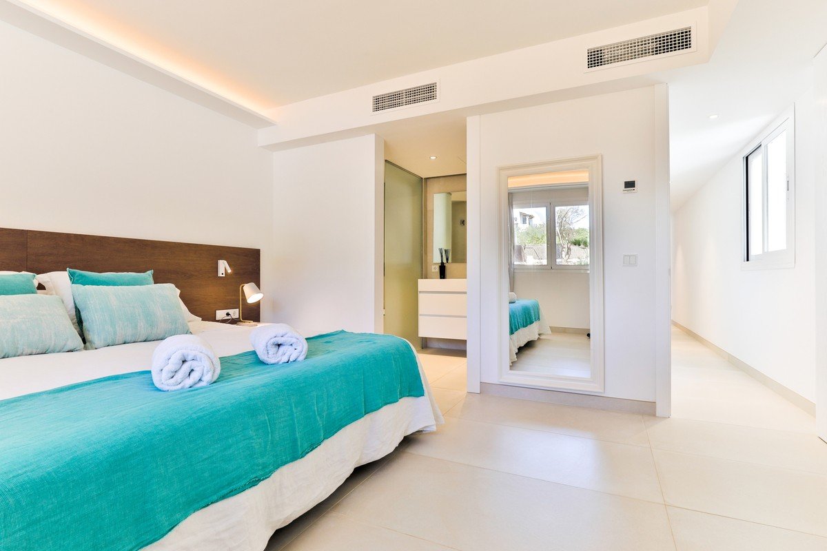 A bedroom with a blue bed and white towels on it