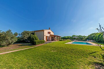 A house with a swimming pool in front of it