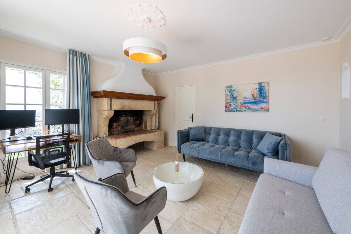 A living room with a couch and chairs and a fireplace