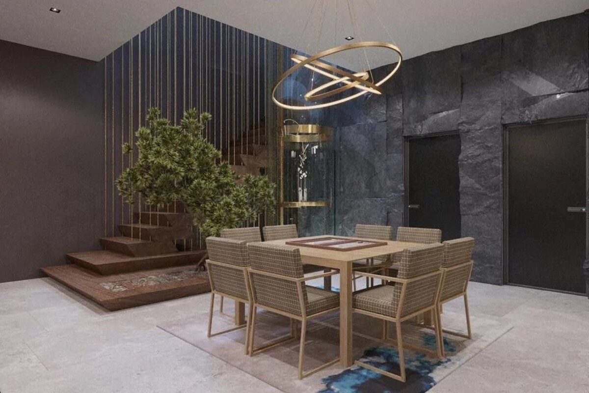 A modern dining area with a wooden table, chairs, a rock wall, a hanging light, and wooden stairs in the background.