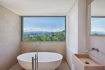 A bathroom with a round bathtub and a large window