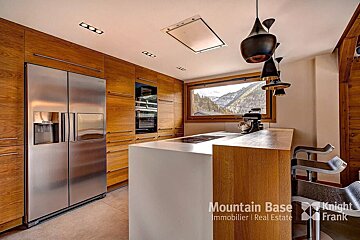 A kitchen with stainless steel appliances and wooden cabinets and a sign that says mountain base