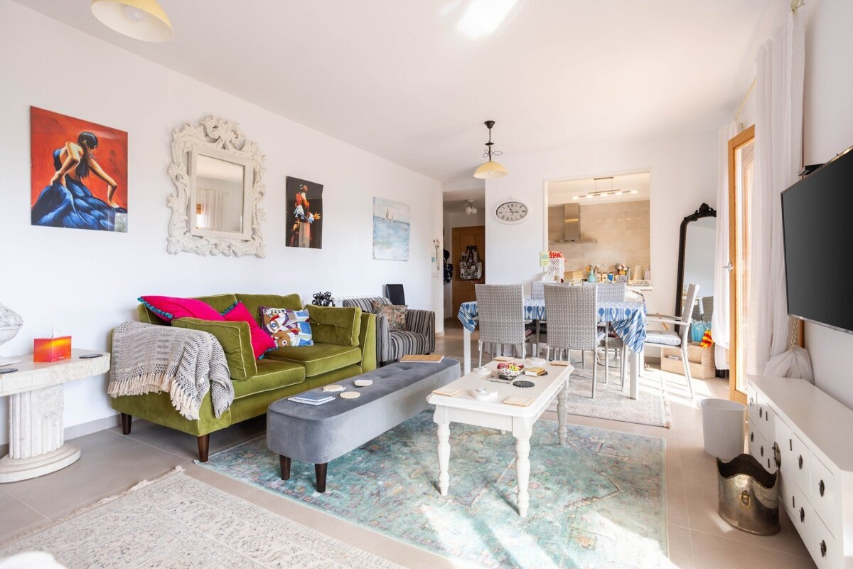 A living room with a green couch and a white coffee table