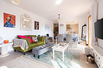 A living room with a green couch and a white coffee table