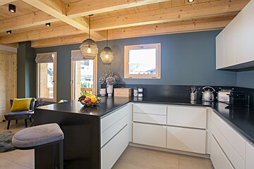 A kitchen with white cabinets and a black counter top