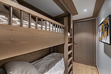 A bunk bed with a painting on the wall above it