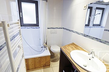 A bathroom with a toilet a sink and a window