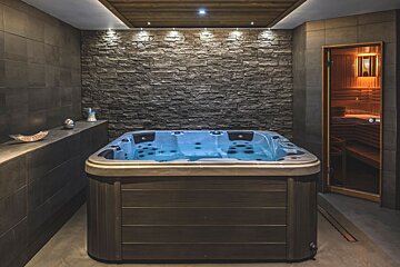 A hot tub in a bathroom next to a sauna