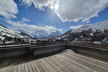 A view of a snowy mountain range from a balcony