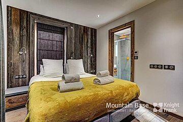 A bedroom with a bed and a sign that says mountain base