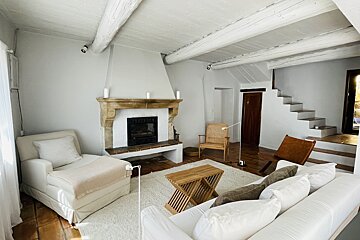 A living room with white furniture and a fireplace