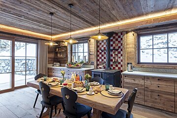 A dining room with a wooden table and chairs