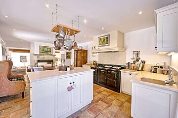 A kitchen with pots and pans hanging from the ceiling