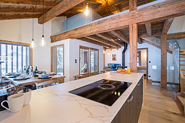 A kitchen with a stove top oven and a marble counter top
