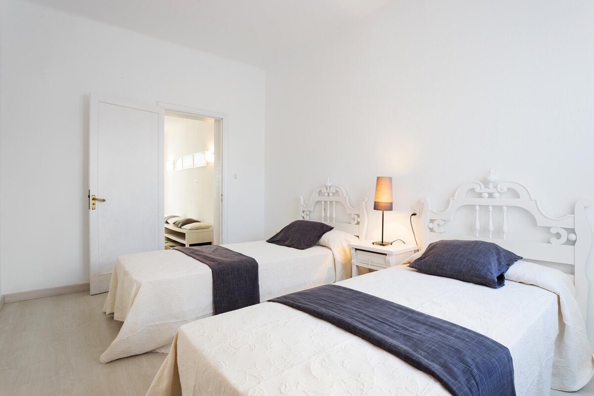 A bedroom with two twin beds and a lamp