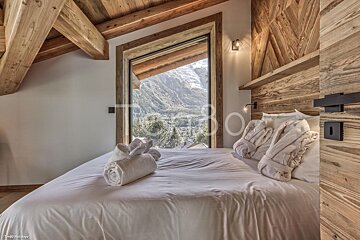 A bedroom with a bed and a window with a view of the mountains