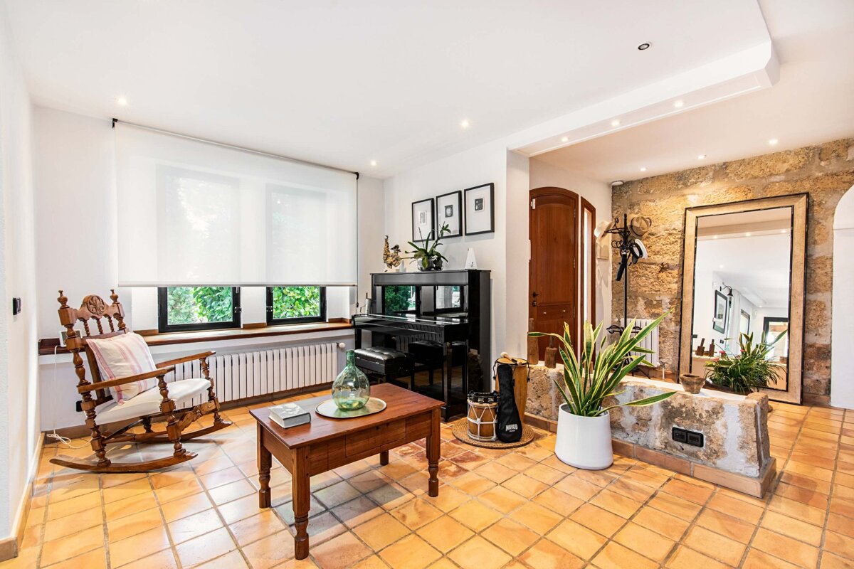 A living room with a rocking chair and a piano