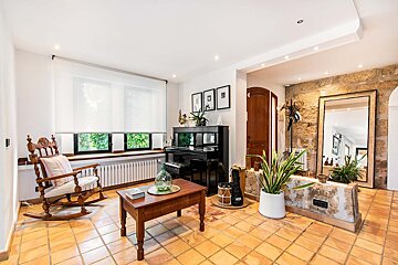 A living room with a rocking chair and a piano