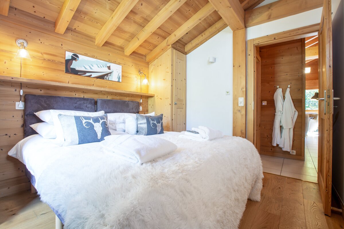 A bedroom with a bed and a picture on the wall