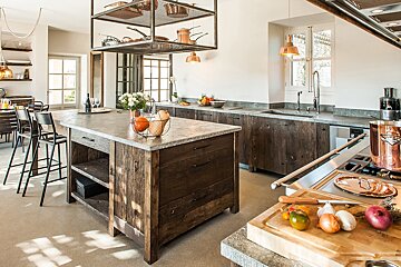 A kitchen with wooden cabinets and copper pots and pans