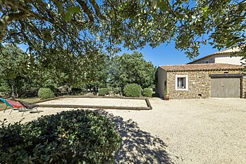 A house with a garage and a sandbox in front of it