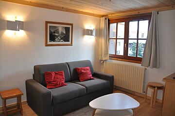 A living room with a couch and a picture on the wall