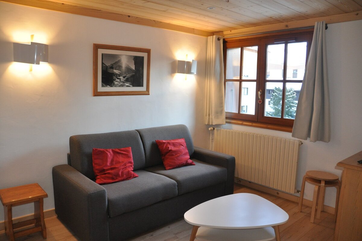 A living room with a couch and a picture on the wall