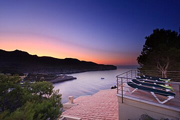 A balcony overlooking a body of water at sunset