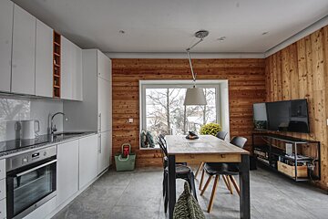 A kitchen with a table and chairs and a television