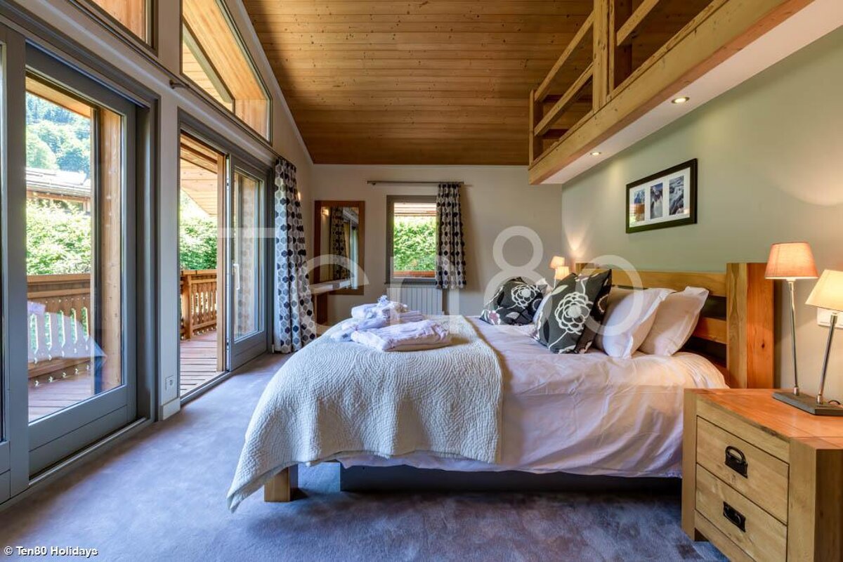 A bedroom with a king size bed and a balcony