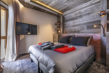A bedroom with a large bed and a flat screen tv