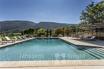 A large swimming pool is advertised by janssens immobilier