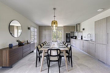 A kitchen with a table and chairs and a mirror