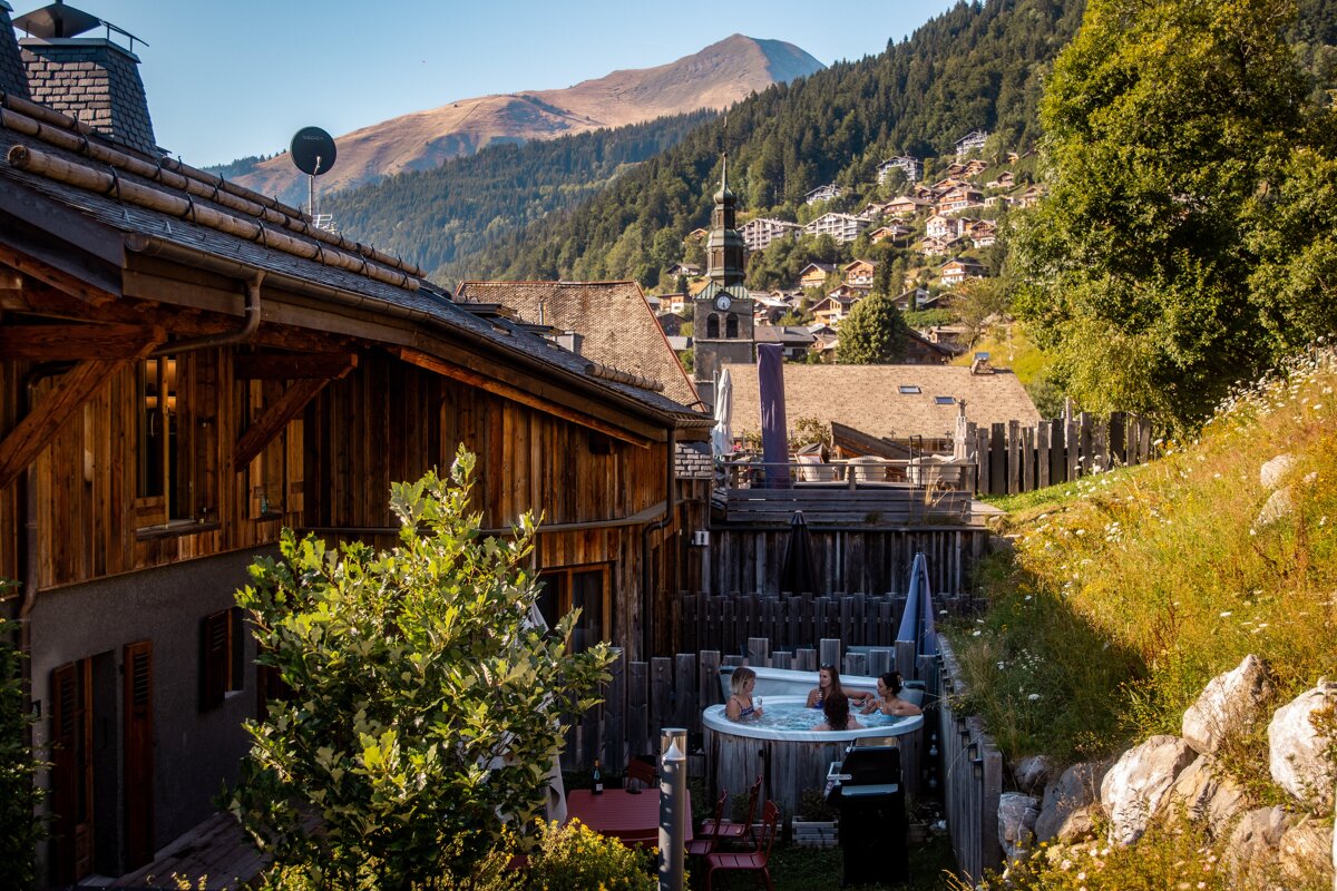 Two people in a hot tub with mountains in the background