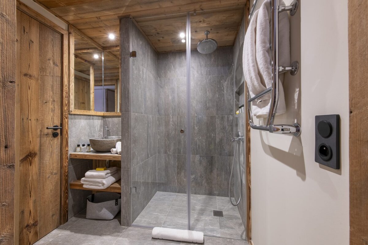 A bathroom with a walk in shower and a sink