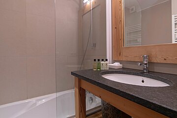 A bathroom with a sink a bathtub and a mirror