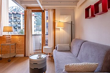 A living room with a couch a table and a lamp