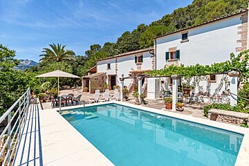 A large white house with a swimming pool in front of it