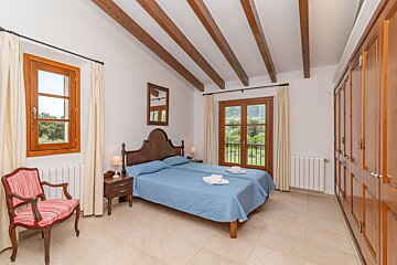 A bedroom with two beds a chair and a window