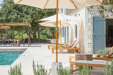 A patio with umbrellas and chairs and the words made in provence by immobilier