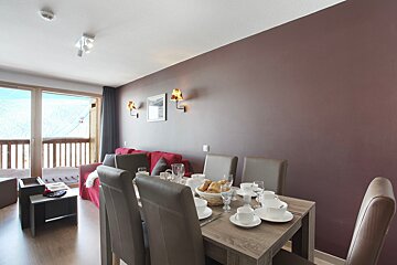 A dining room table with a basket of bread on it