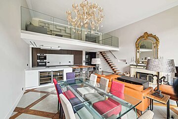 A dining room with a glass table and chairs