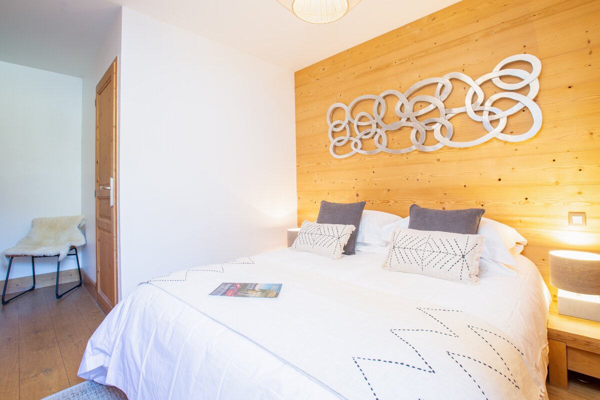 A bed in a bedroom with a wooden headboard