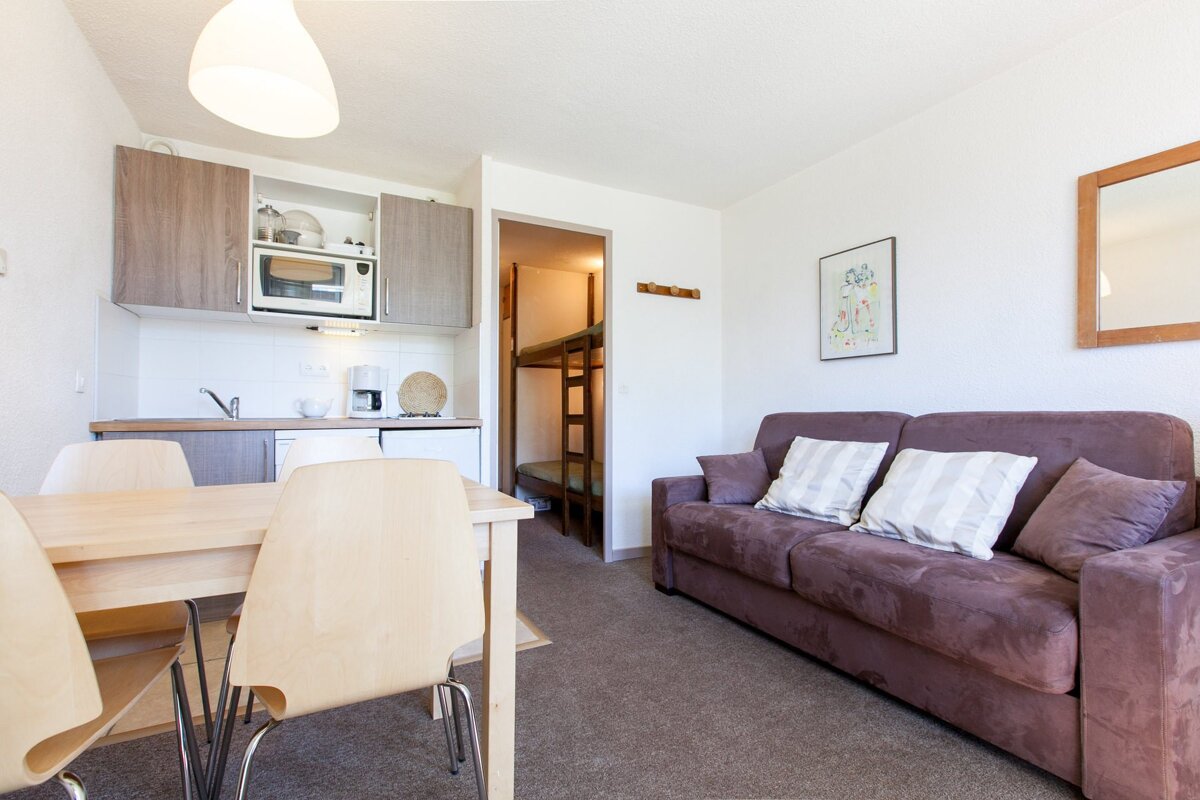 A living room with a couch and a table and chairs