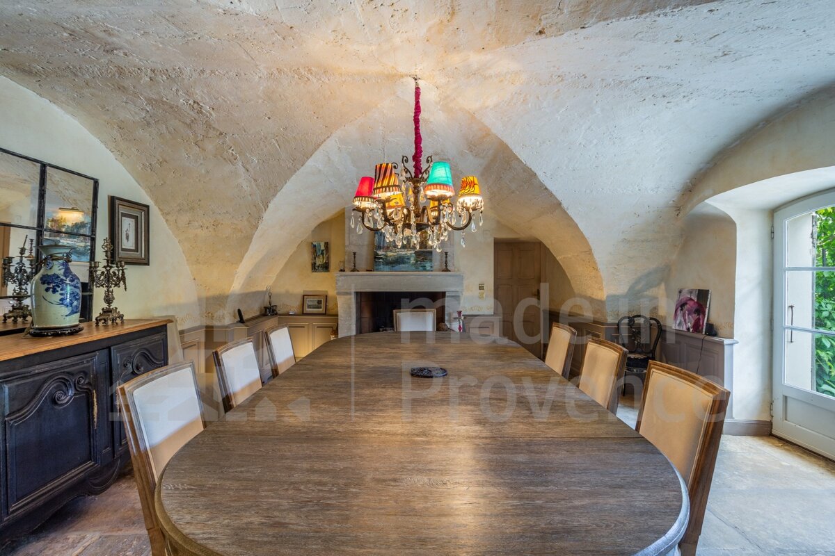 A dining room with a long table and chairs and a chandelier