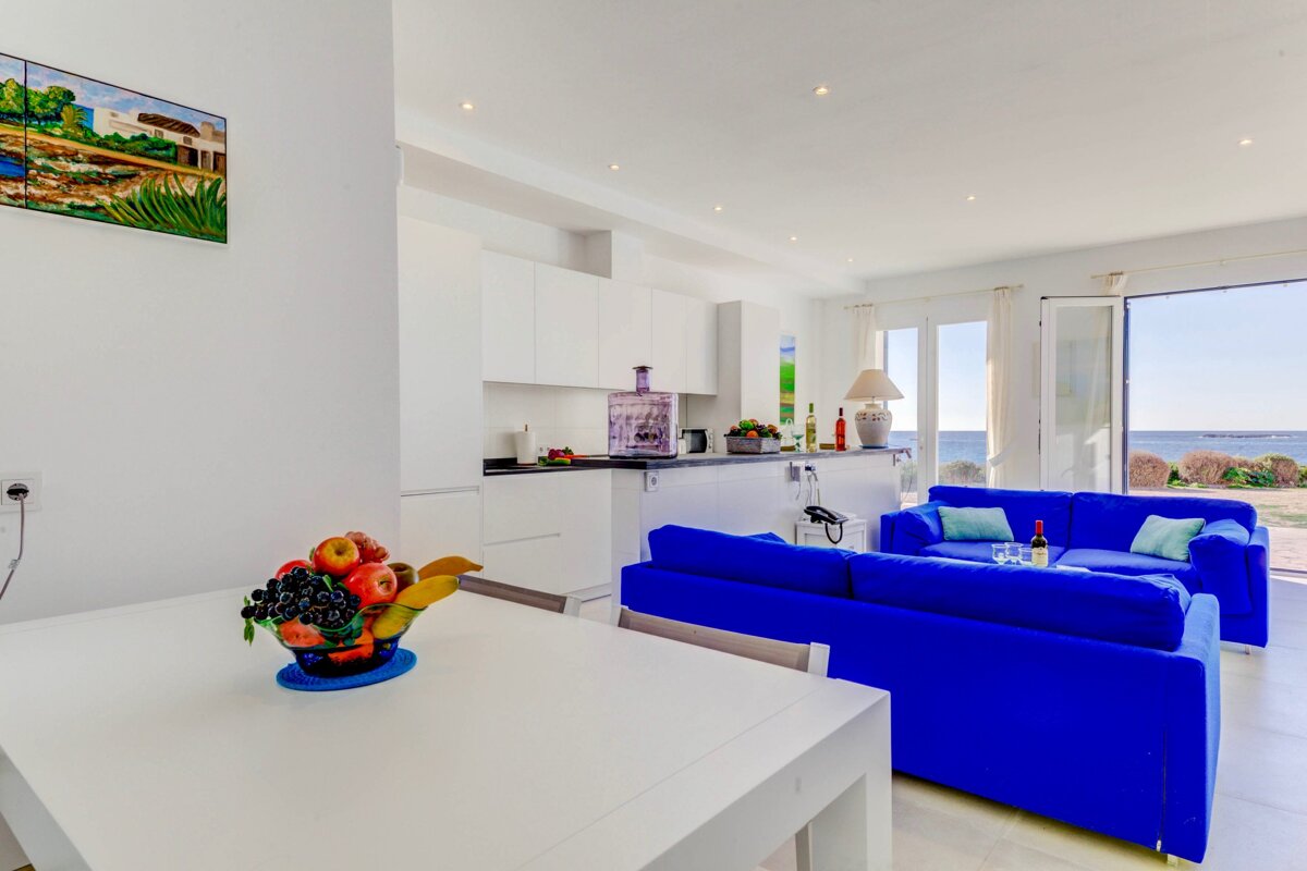 A living room with a blue couch and a white table