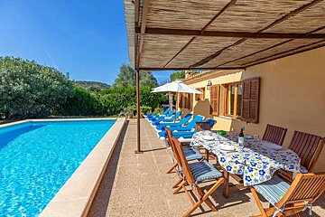 A table and chairs in front of a swimming pool