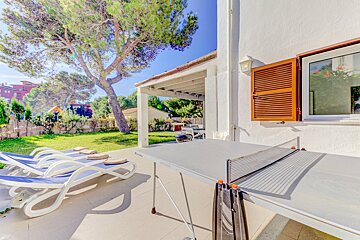 A ping pong table sits outside of a house