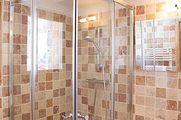 A bathroom with a walk in shower and a mirror